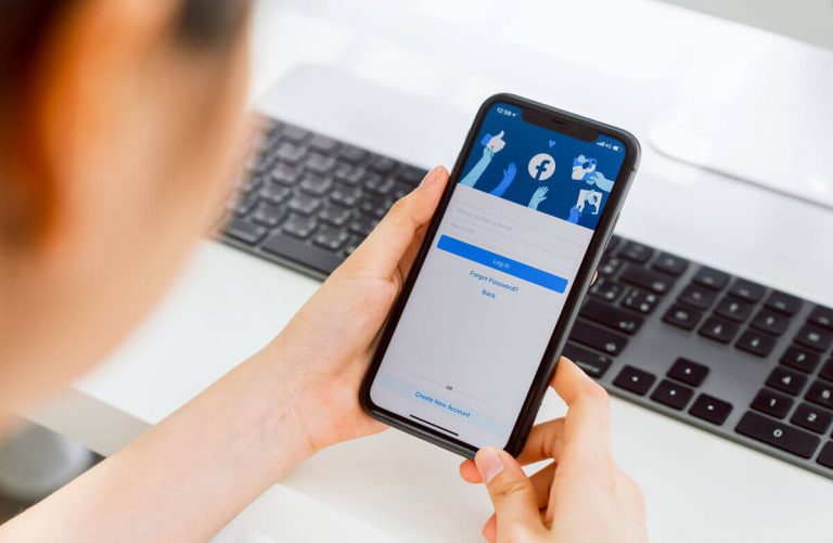 Oseba drži pametni telefon s prijavo v aplikacijo.