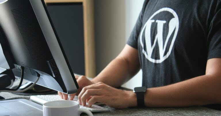 Oseba dela na računalniku z logotipom WordPress