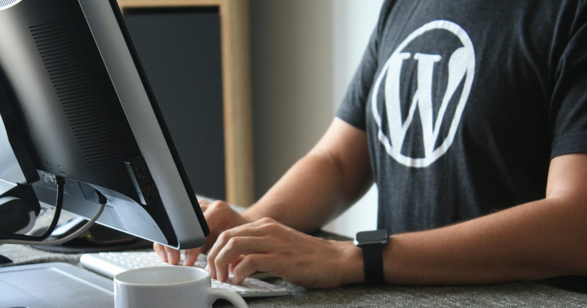 Oseba dela na računalniku z logotipom WordPress
